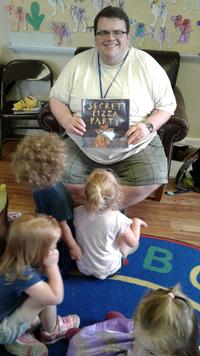 Mark Costello reads to a group of children.
